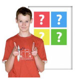 A boy pointing forward in front of a poster with question marks on it