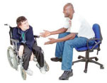 Man sitting on a chair talking to a man in a wheelchair