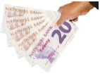 A hand holding twenty pound notes